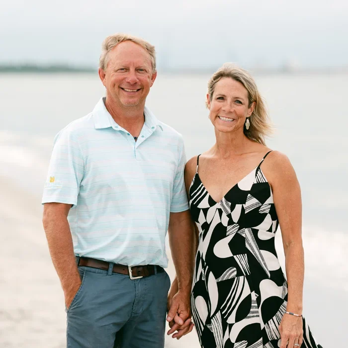 Russell Davis and his wife standing together and smiling by the water.
